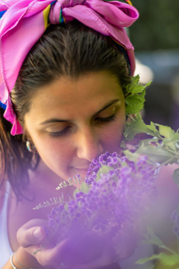 Close-up portrait of woman holding purple flower