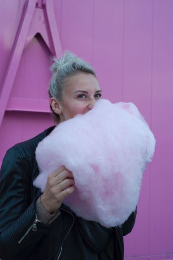 Woman looking away while eating cotton candy