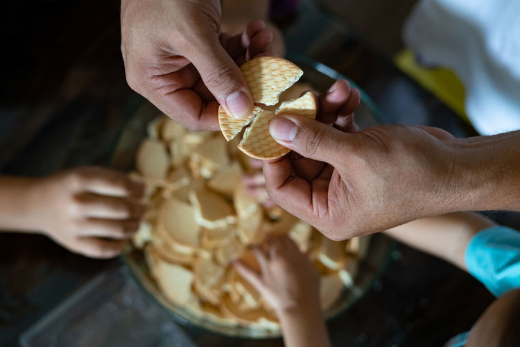 Kids making kek batik or malaysian triple chocolate dessert. crushing the cookies into tiny pieces