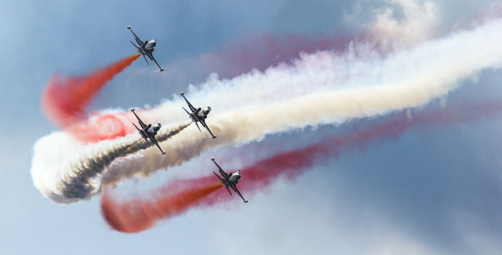 Low angle view of airshow against sky