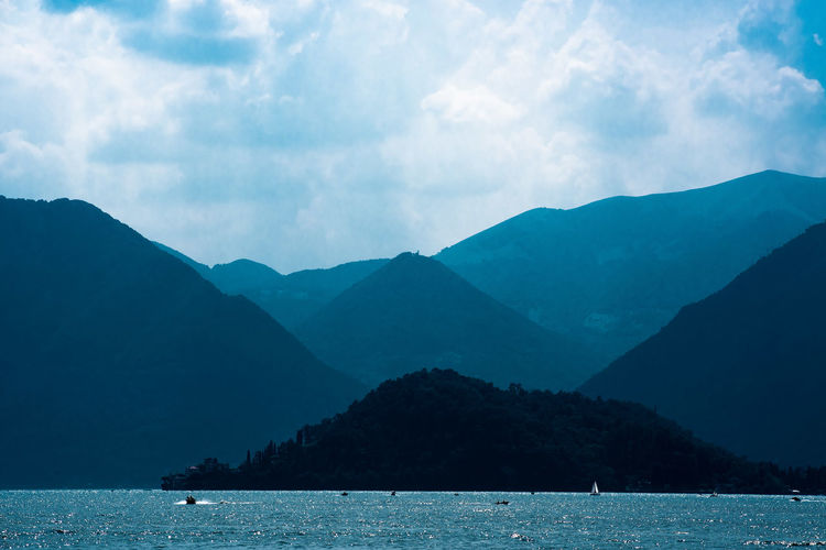 Scenic view of sea and mountains against sky