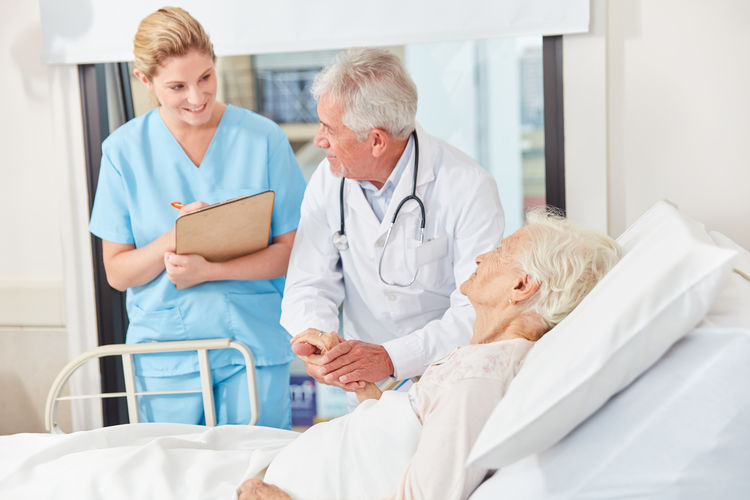 Smiling nurse talking with patient at hospital