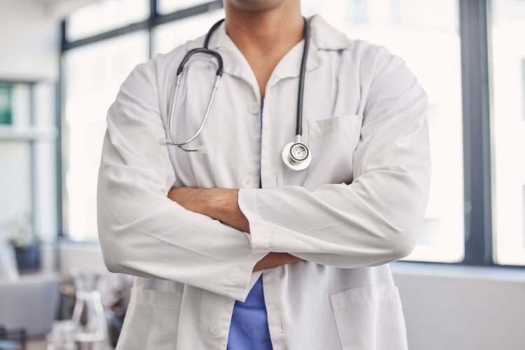 Midsection of doctor holding stethoscope
