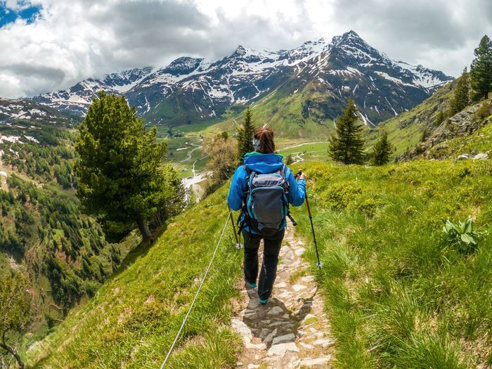 Woman hiking on footpath in the austrian alps near gastein, salzburg, austria
