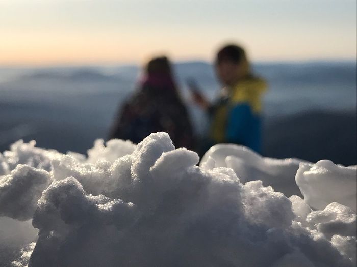 Close-up of snow with people in background