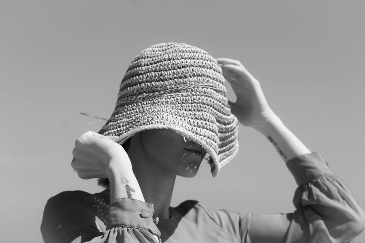 Close-up of man wearing hat against clear sky