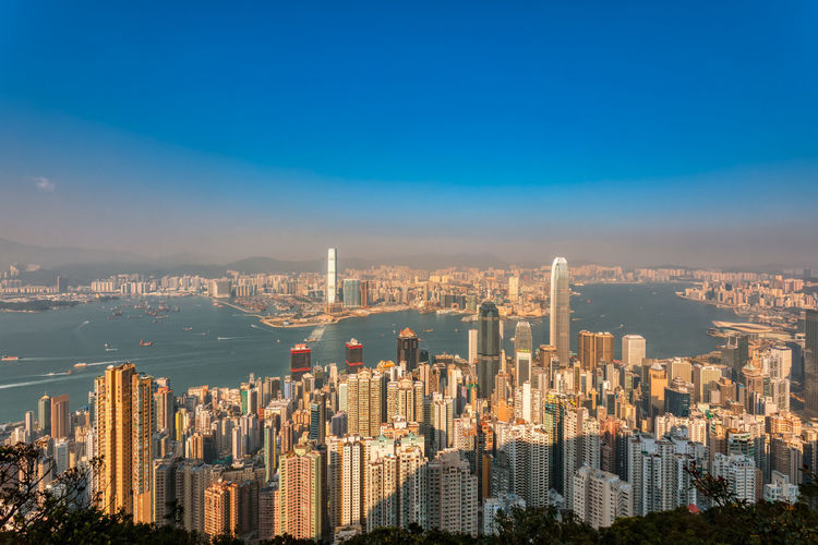 Aerial view of city buildings against blue sky