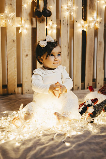 A baby girl in a photo set taking christmas photos