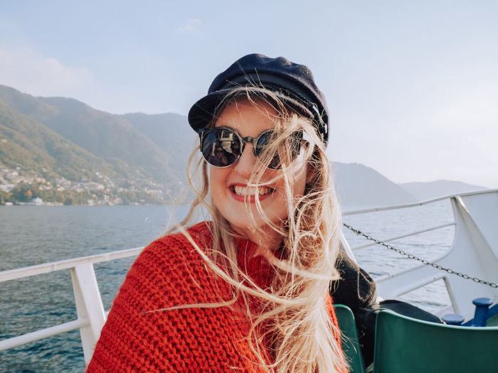 Close-up portrait of smiling young woman on boat sailing in sea