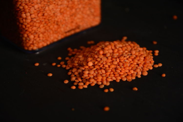 Close-up of red lentils against black background