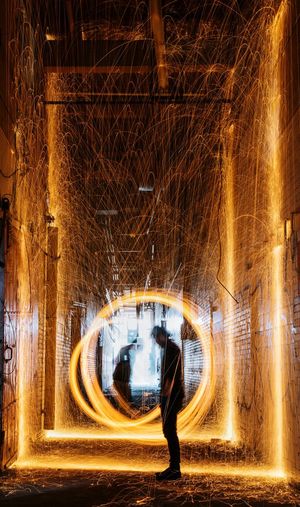Side view of man performing with light painting