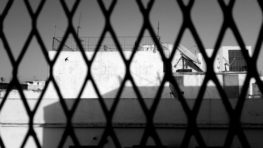 Chainlink fence against building in city