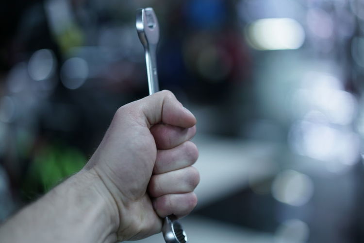 Close-up of person holding wrench