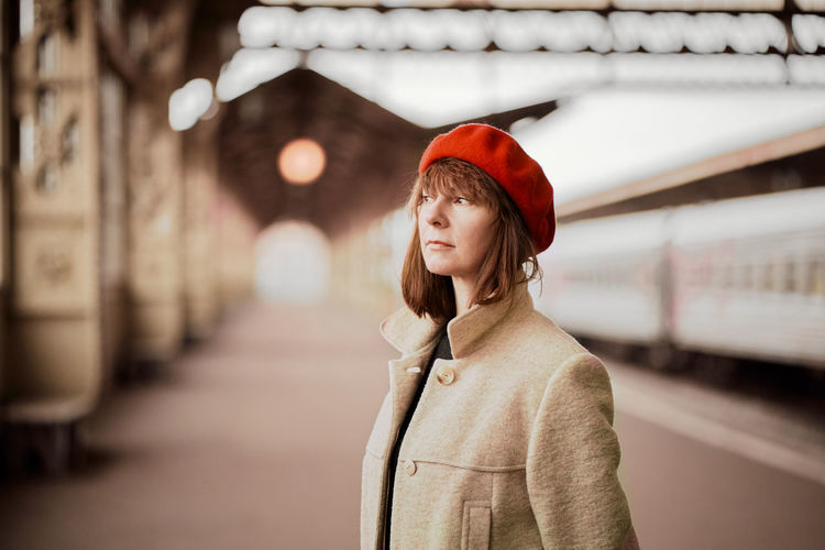 Smiling woman standing on railroad station