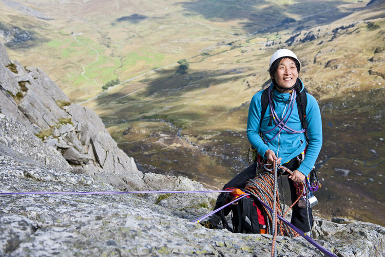 Female rock climber at belay anchor point on tryfan in north wales