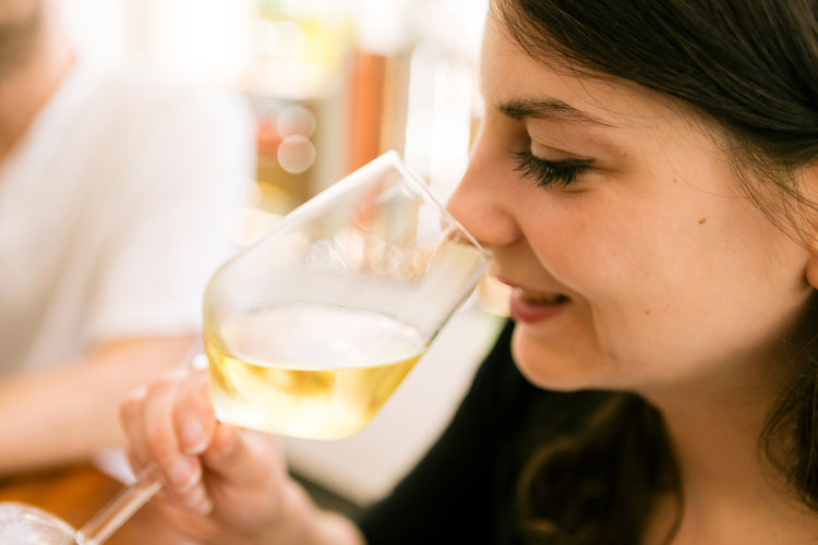 Woman smelling a glass of white wine