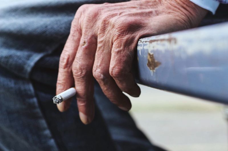Cropped image of man holding cigarette