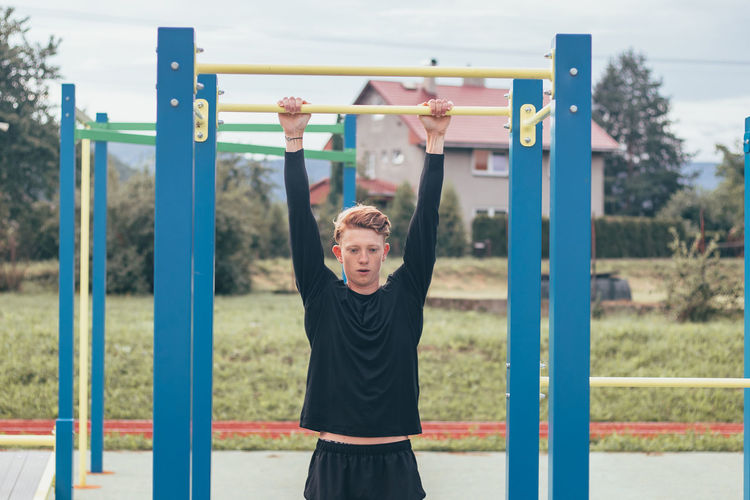 Athlete stretches and strengthens his arms, shoulders and pectoral muscles with trx fitness straps