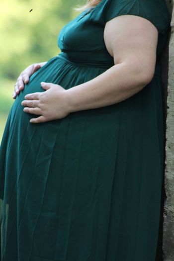Midsection of pregnant woman standing outdoors