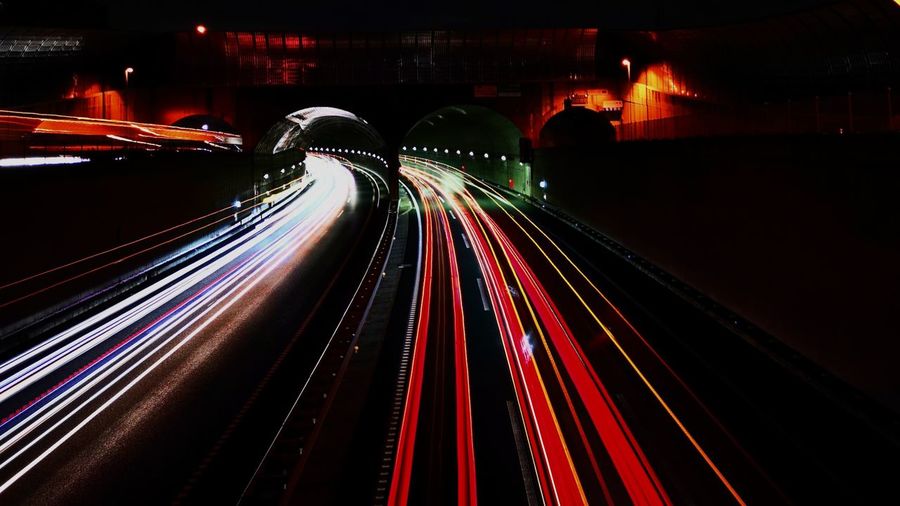 Light trails on illuminated bridge at night