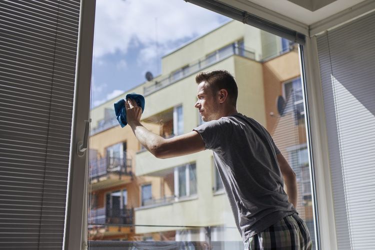 Man cleaning window with rag at home. themes housework and housekeeping.
