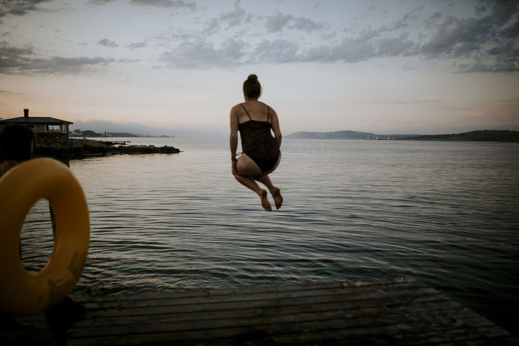 Woman jumping into water