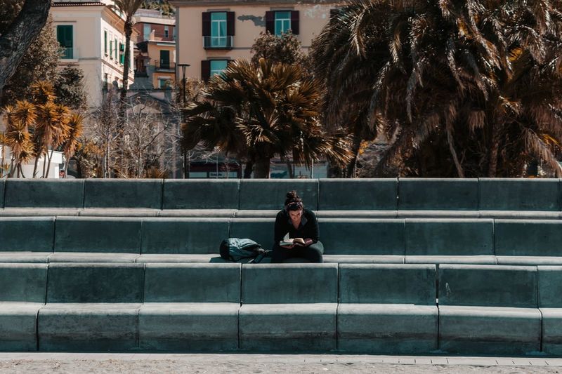 Man sitting on bench in city