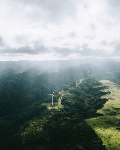 High angle view of wind turbines on field against sky during foggy weather