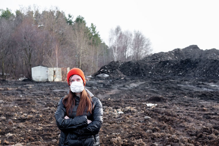 A woman stands in a mask