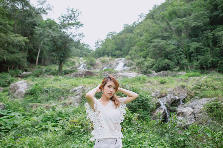 Beautiful young asian woman travel to visit waterfall forest in vacation trip at thailand.