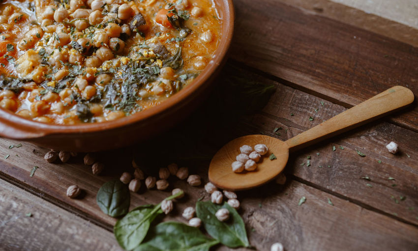 Wooden spoon and potaje. typical spanish food. vegan food. chickpeas with chard.
