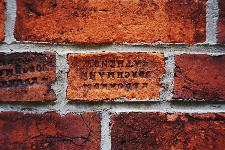 Close-up of text on brick wall