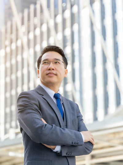 Mid adult man standing in front of office building