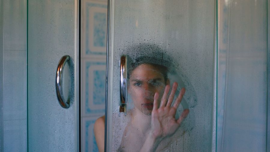 Close-up of young woman with window