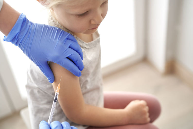Doctor giving vaccine to girl