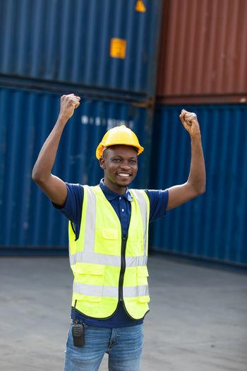 Portrait of a smiling young man standing at warehouse