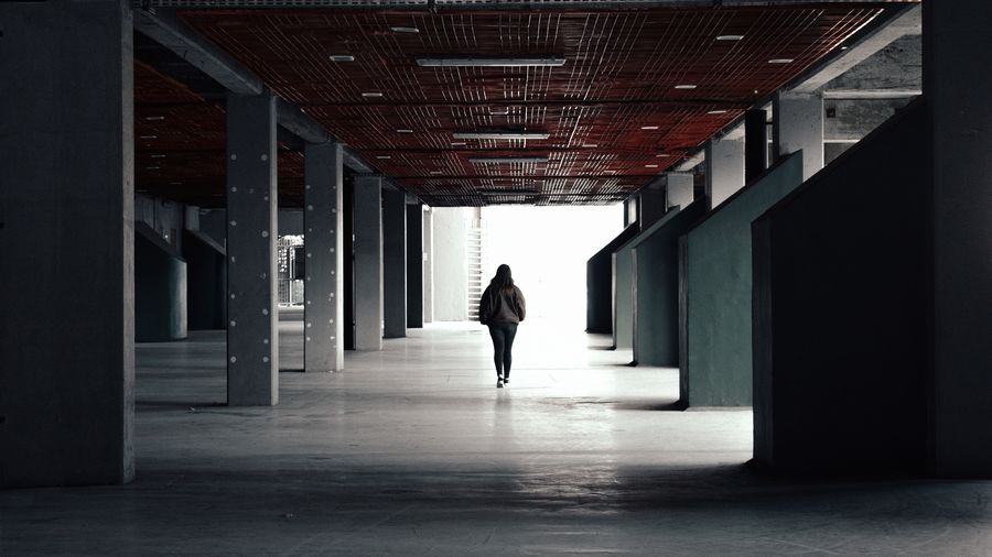 Rear view of woman walking in parking lot