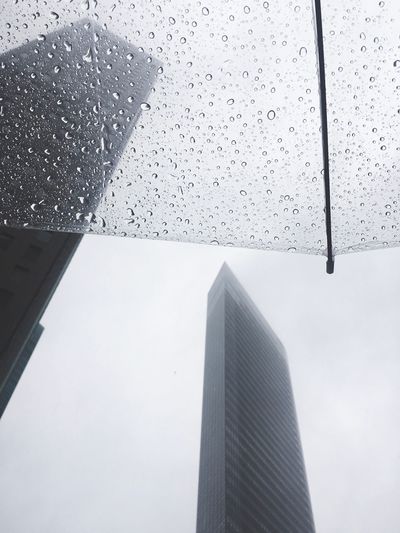 Low angle view of wet umbrella in city during rain
