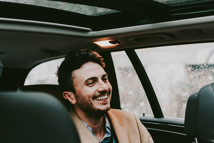 Portrait of smiling young man in car