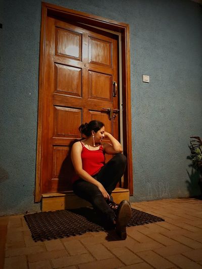Woman sitting at doorway of home