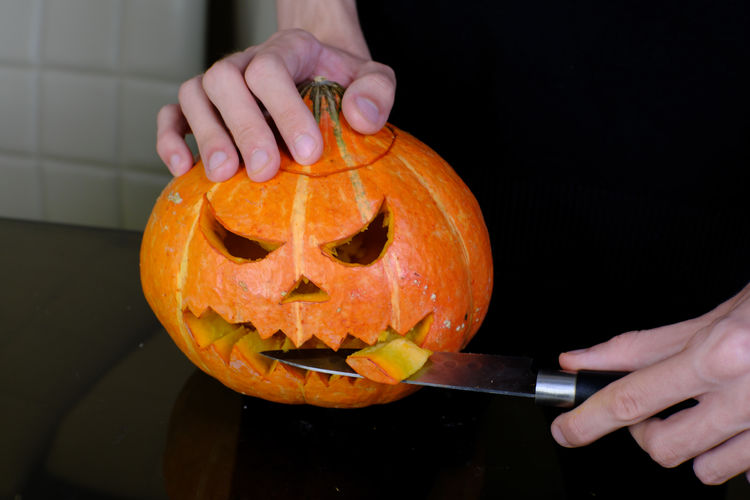 Cropped image of person hand holding pumpkin