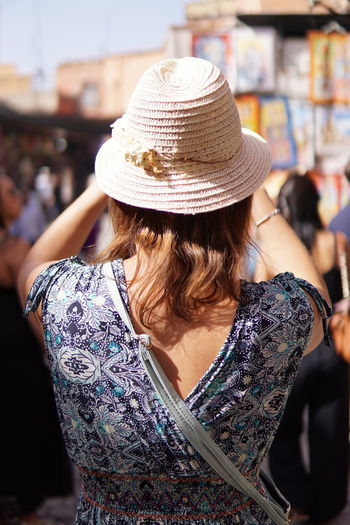 Rear view of woman wearing hat standing in market