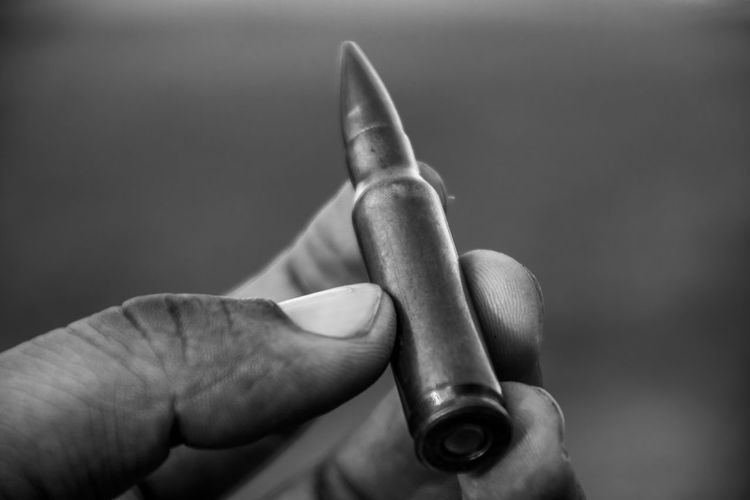 Close-up of hand holding bullet