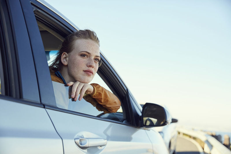 Young woman looking out of a car
