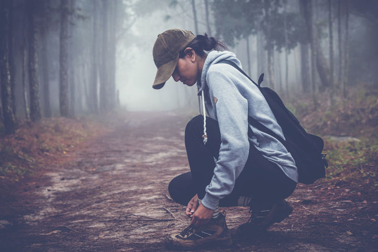 Side view of woman in forest during foggy weather