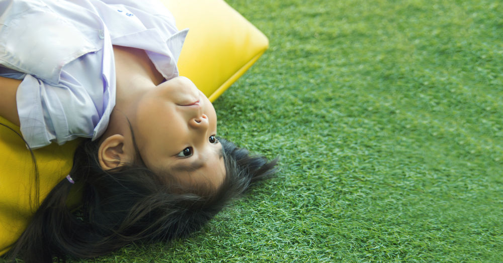 High angle portrait of cute baby lying on field