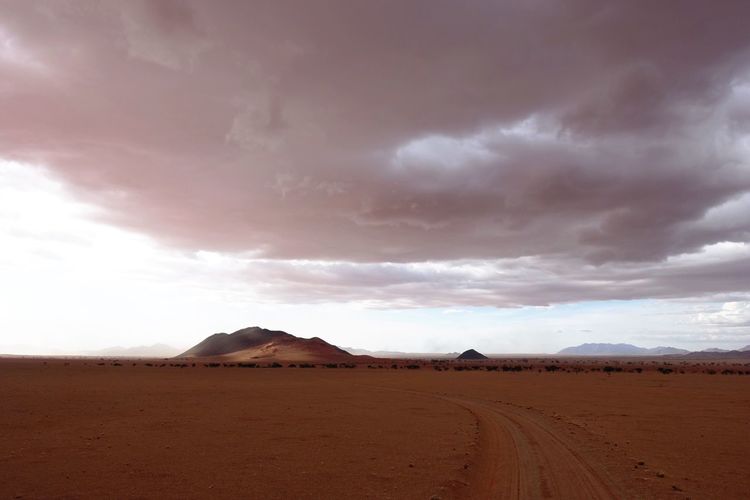 View of desert against cloudy sky