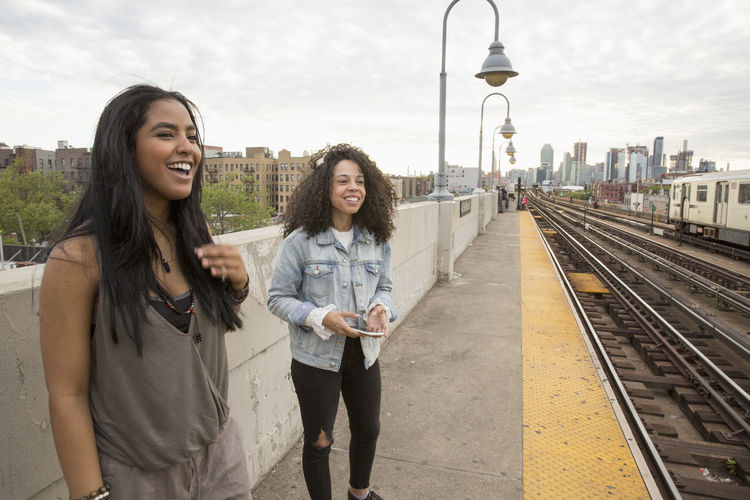 Young women waiting at a train station in queens