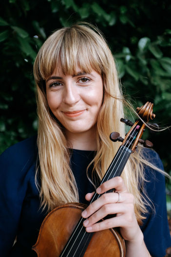 Portrait of smiling woman holding violin
