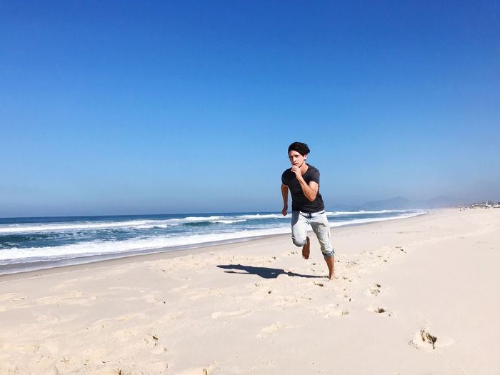 Full length of young man running on beach